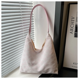 Detail of light pink tote bag featuring a 3D geometric woven texture and leather strap
