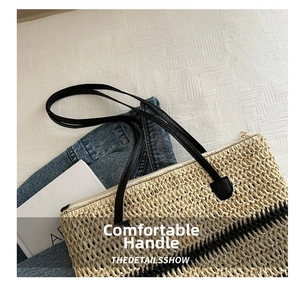 Detail of straw bucket tote bag featuring black woven stripes and long leather handles