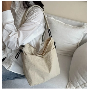 Détail du sac cabas beige en nylon avec texture plissée et bandoulière en corde bicolore