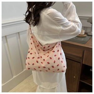 Détail du sac fourre-tout en velours rose avec imprimé fraises pour les loisirs