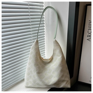 Detail of white textured tote bag with mint green strap under artistic shadow light