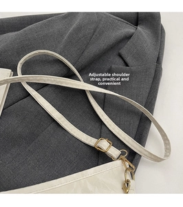 Close-up of the adjustable white leather shoulder strap with golden metal buckle hardware