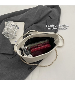 Top view of white bucket bag showing large interior for phone, wallet and perfume