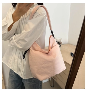Gros plan d'un sac hobo rose clair avec détail élégant de corde tressée noire et blanche