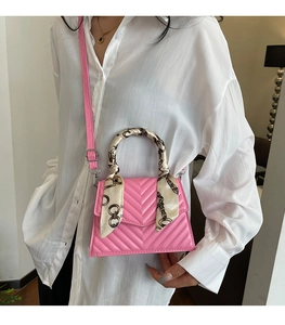 Pink quilted crossbody bag with silk scarf handle detail worn by a model in white