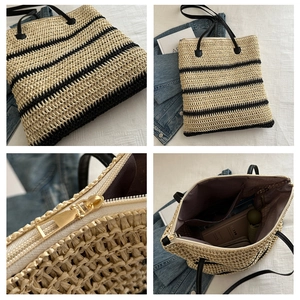 Detail view of woven straw tote bag featuring black stripes and functional inner pockets