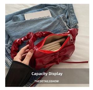 Interior view of the red bow shoulder bag showing storage capacity for wallet and phone
