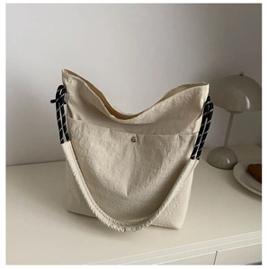 Gros plan sur un grand sac fourre-tout en nylon beige avec fermeture magnétique