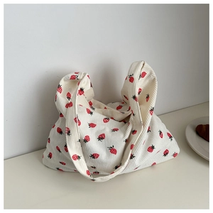Détail du sac cabas en velours côtelé crème avec motifs fraises et texture douce