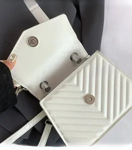 Detail view of white chevron quilted bag showing silver magnetic closure and inner lining