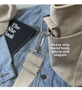 Close-up of durable metal hook and thick woven strap on a beige canvas tote bag