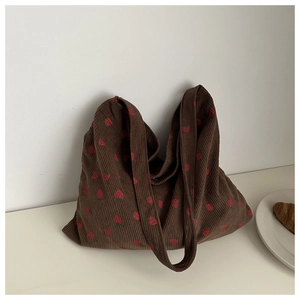 Détail du sac tote en velours côtelé marron avec imprimé fraise et texture souple