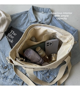Spacious interior of beige canvas tote bag showing storage for umbrella and phone