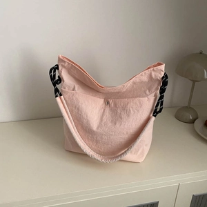 Sac fourre-tout beige minimaliste avec une bandoulière à nœuds noirs et blancs stylée