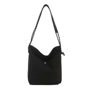 Sac seau minimaliste en toile noire avec bandoulière tissée et grand compartiment femme