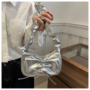 Detail of silver metallic handbag with bow accent and ruched cloud shoulder strap