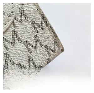 Macro shot of off-white lychee texture leather with monogram M dot pattern and fine stitching