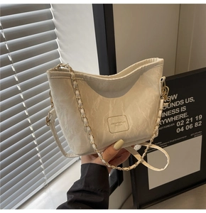 Detail of white marble pattern crossbody bag with metal chain and brand logo