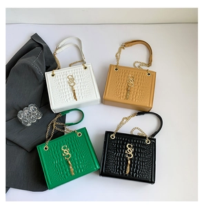 Details eleganter Umhängetaschen mit Krokoprägung in vier Farben und Goldquasten