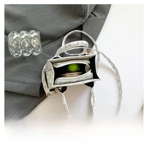 Top view of white crossbody bag with M-logo print showing spacious internal zippered compartment