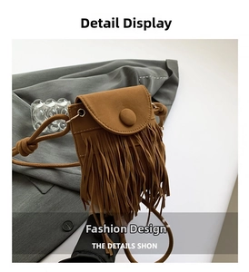 Detailed view of brown faux suede crossbody bag with long tassels and curved flap