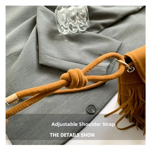 Detail of adjustable knotted shoulder strap on brown suede fringe crossbody bag
