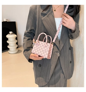 Detail of pink mini handbag with all-over M letter print and slim leather shoulder strap