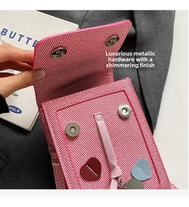 Close-up of woven square bag with magnetic buckles and colorful heart pendants