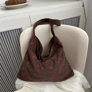 Sac fourre-tout en velours côtelé marron avec imprimé fraise sur chaise blanche