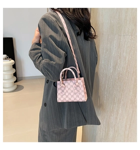 Detail of pink monogram mini handbag styled with grey striped suit for fashion look