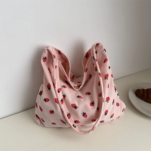 Sac fourre-tout rose en velours côtelé à motif fraises dans un décor de style