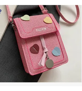 Detailed shot of pink woven crossbody phone bag with colorful heart patches and fashion text