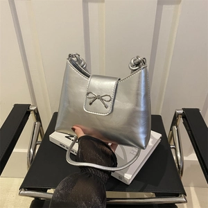 Chic silver underarm bag featuring a metallic bow and knotted strap design for women