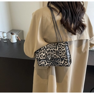 Detail of leopard print rectangular shoulder bag with black chain strap and silver buckle
