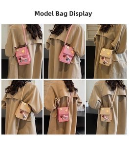 Vertical crossbody phone bag with heart patches and tassels shown on a model