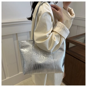 Detailed side view of silver tote bag with crocodile embossing and metallic luster