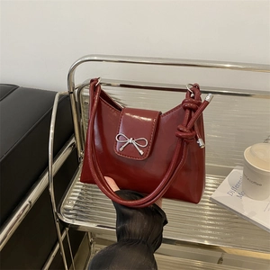 Chic burgundy underarm bag with silver bow accent and knotted shoulder strap