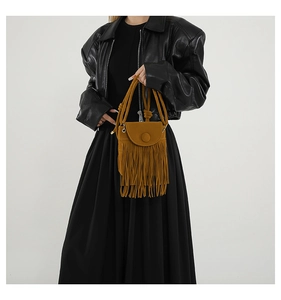 Detail of caramel fringe crossbody bag with retro tassels and magnetic buckle on model