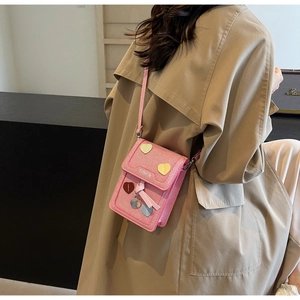 Pink woven phone bag with heart patches shown on a trench coat model for daily styling