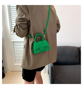 Vista posteriore di una modella con la mini borsa a tracolla verde brillante e blazer marrone