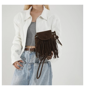 Detail of dark brown suede crossbody bag with long tassels and bohemian design