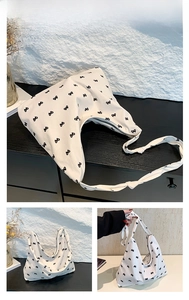 Detail of white canvas tote with black bow prints and knotted shoulder strap design