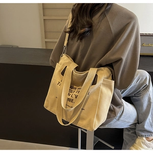 Detail showing side pockets and large capacity of the beige canvas tote bag