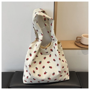 Close-up of strawberry print corduroy tote bag showing soft texture and cream white base