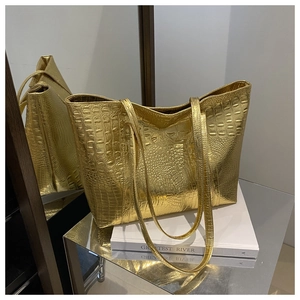 Detailed macro shot of glossy golden tote bag with embossed crocodile leather texture