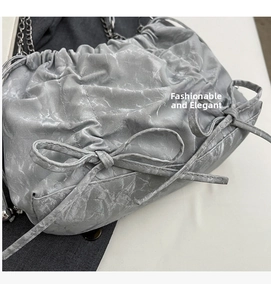 Détail du sac seau plissé gris argenté avec texture marbre et bandoulière chaîne