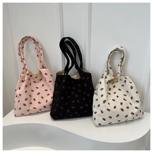 Detailed texture of corduroy tote bags with strawberry patterns in three colors