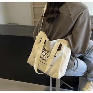 Canvas tote bag side view on model showing spacious capacity and wide strap
