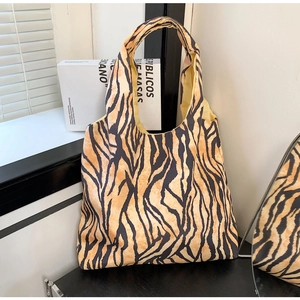 Detailed view of spacious tote bag with orange and black tiger print and sturdy handles