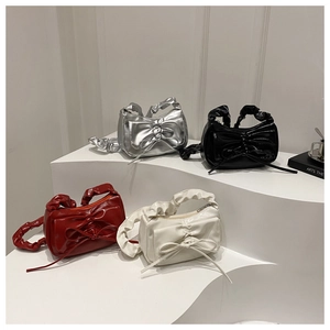 Detail of sweet bow-accented pleated handbags in metallic silver, black, red, and white colors